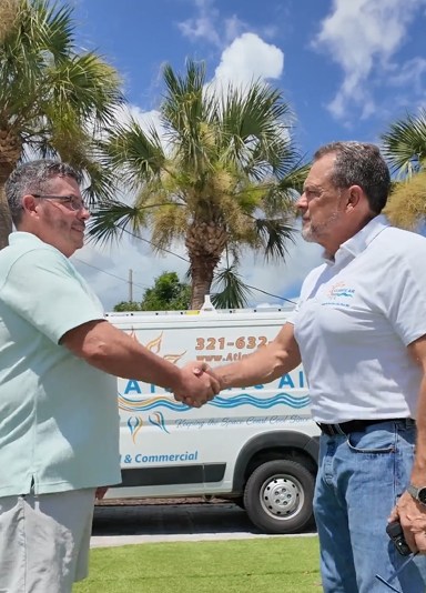 Ken North, owner of Atlantic Air, shaking hands in front of an Atlantic Air van